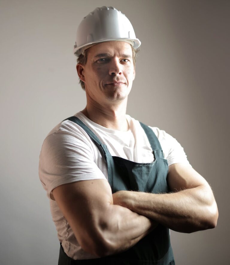 Serious adult constructor in helmet and uniform